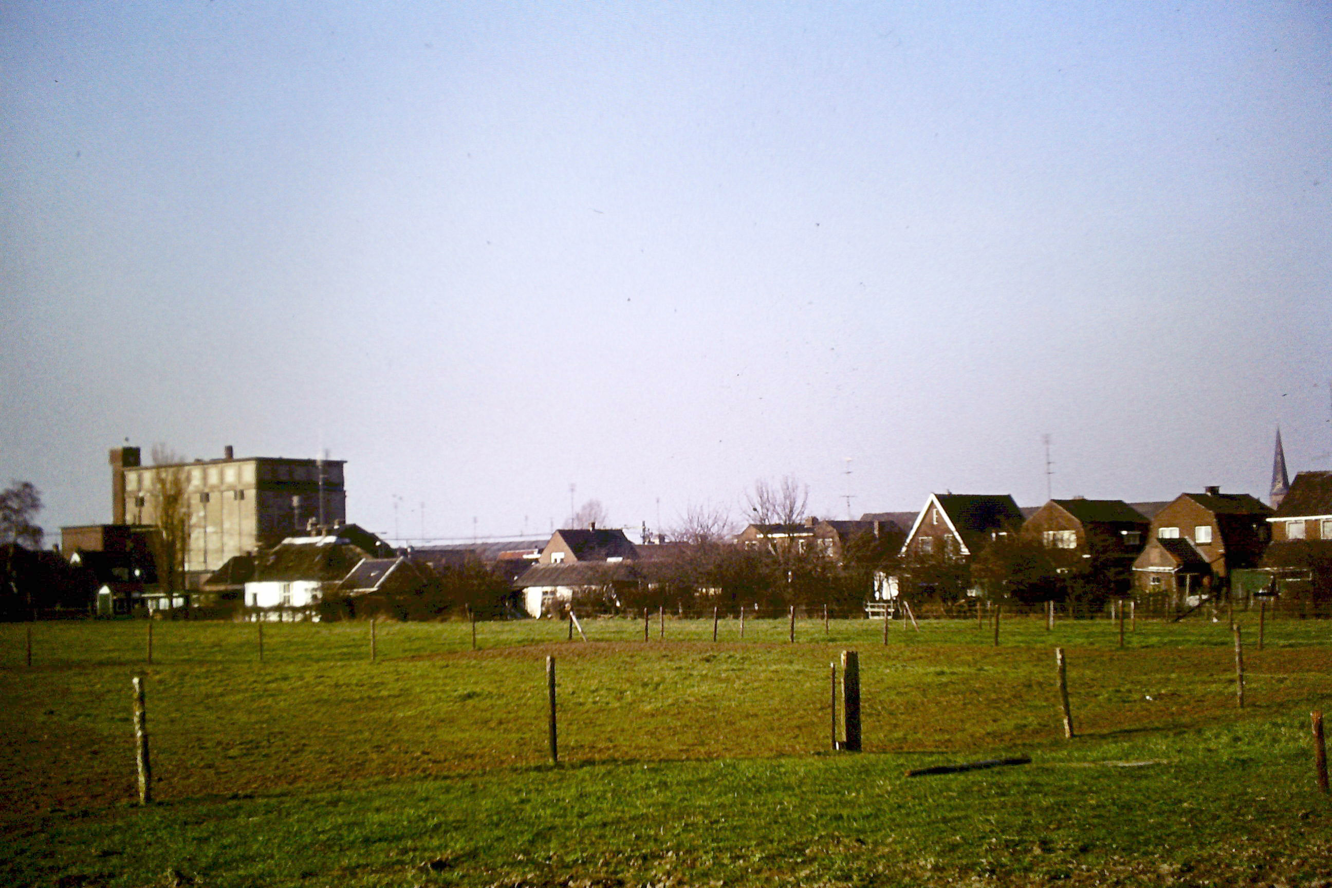 Wijhe, Dorp, de fotograaf stond op het land van de Beuze en fotografeerde de Enkweg van de achterkant. Vloerzeilfabriek.